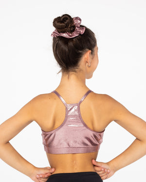 Woman wearing a pink sports bra with a plain background