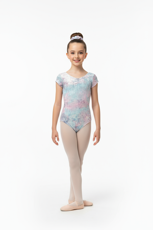 Young girl in a floral leotard and beige tights on a white background